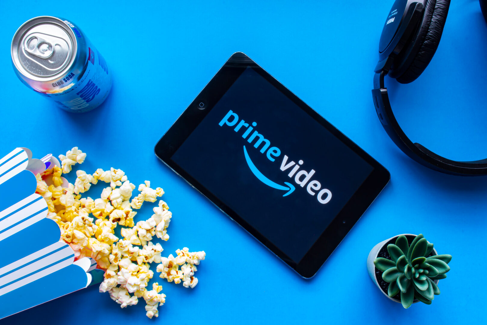image of a tablet with prime video on the screen, popcorn and headphones