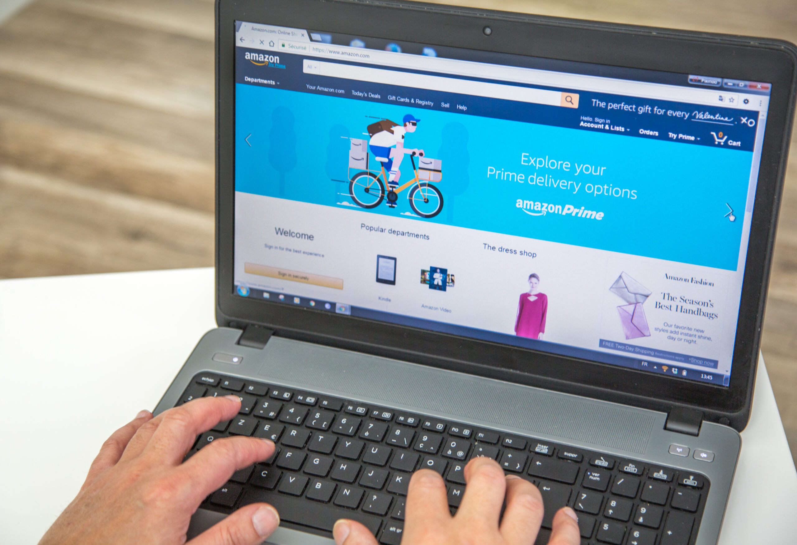 Image of a person using a laptop with Amazon open on the screen