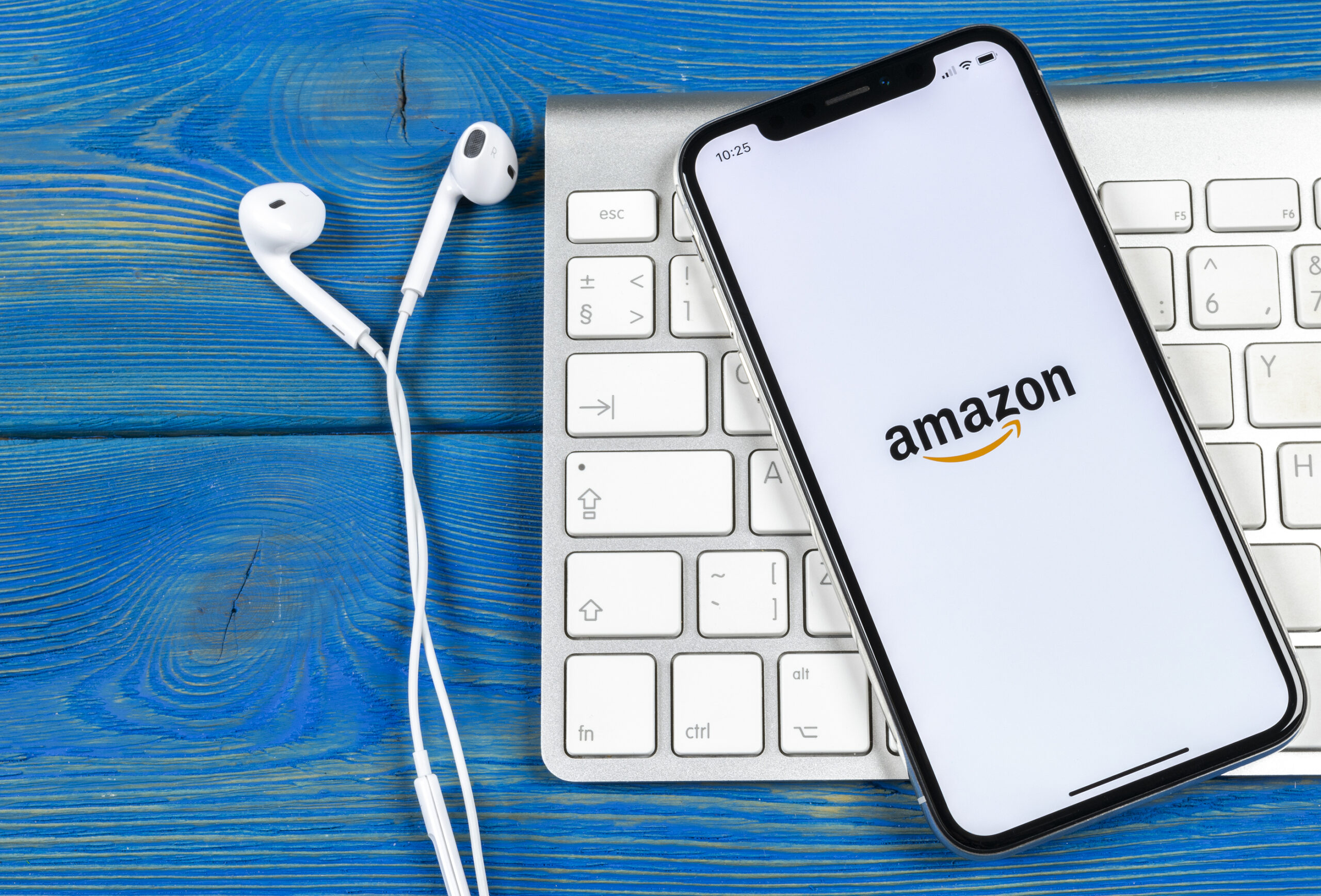 A phone with Amazon open on the screen on top of a keyboard