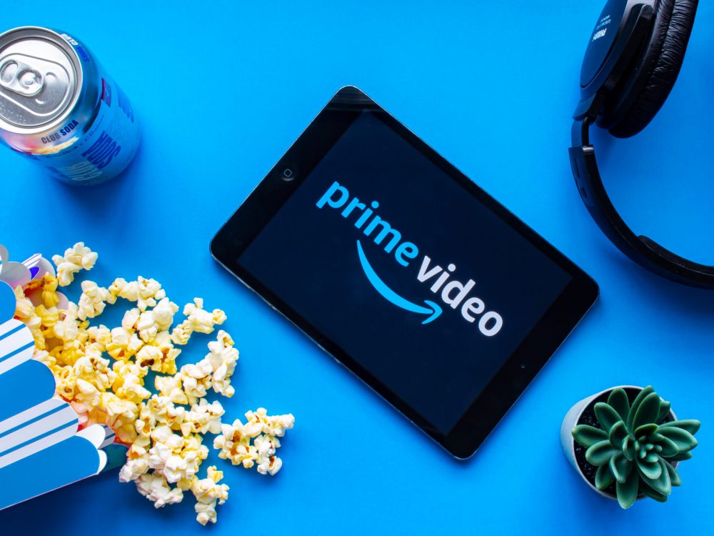 image of a tablet with prime video on the screen, popcorn and headphones